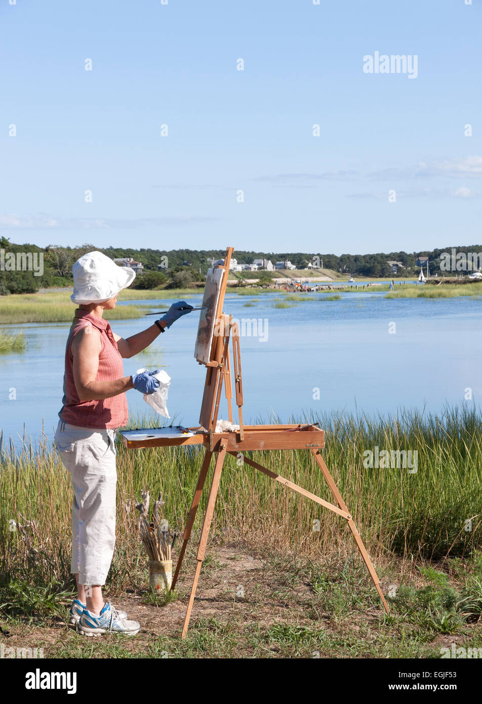 Female artist painting scenic Duck Creek in Wellfleet, Massachusetts. Stock Photo