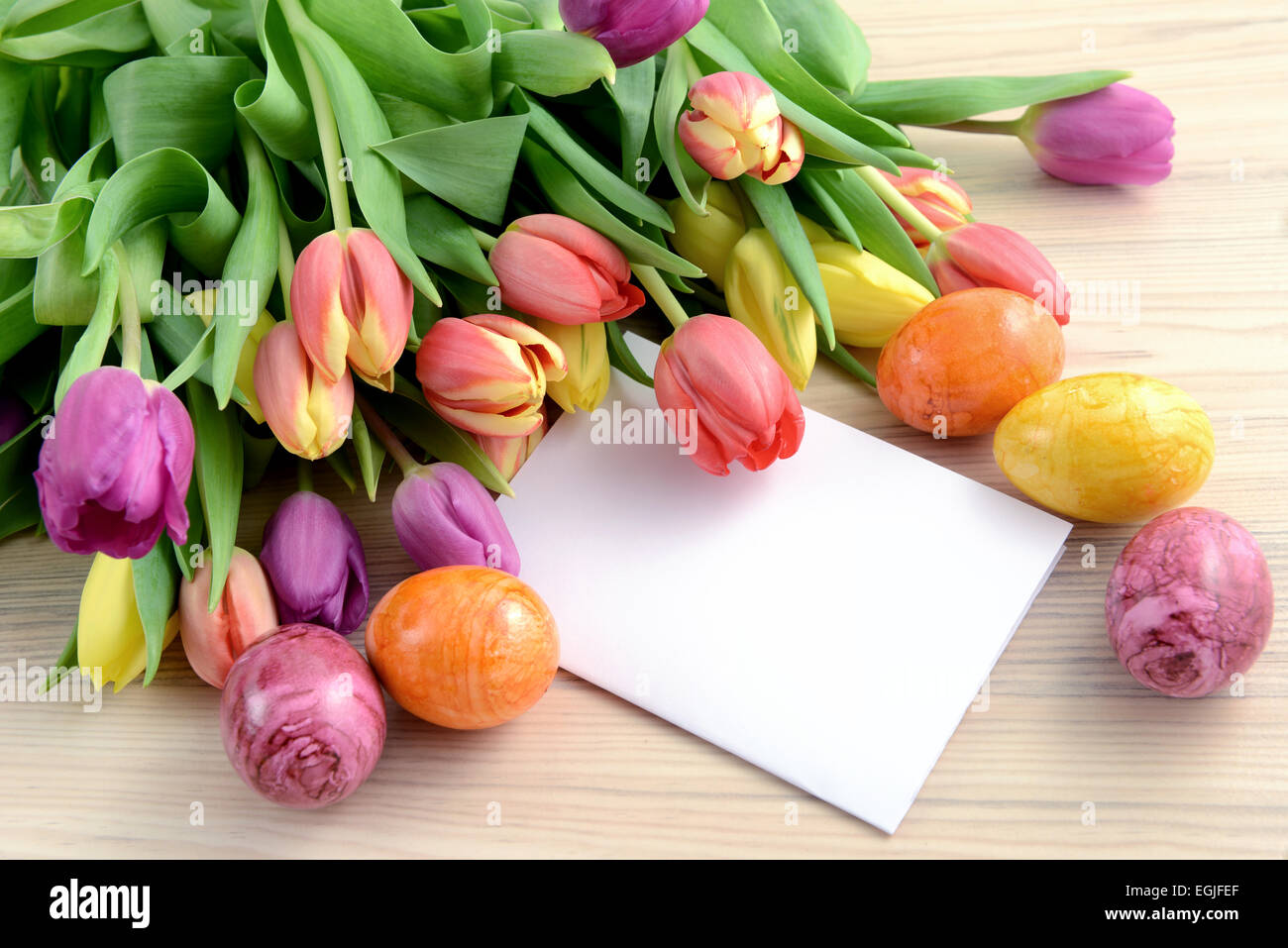 Bunch of tulips with easter eggs and note paper copy space Stock Photo ...