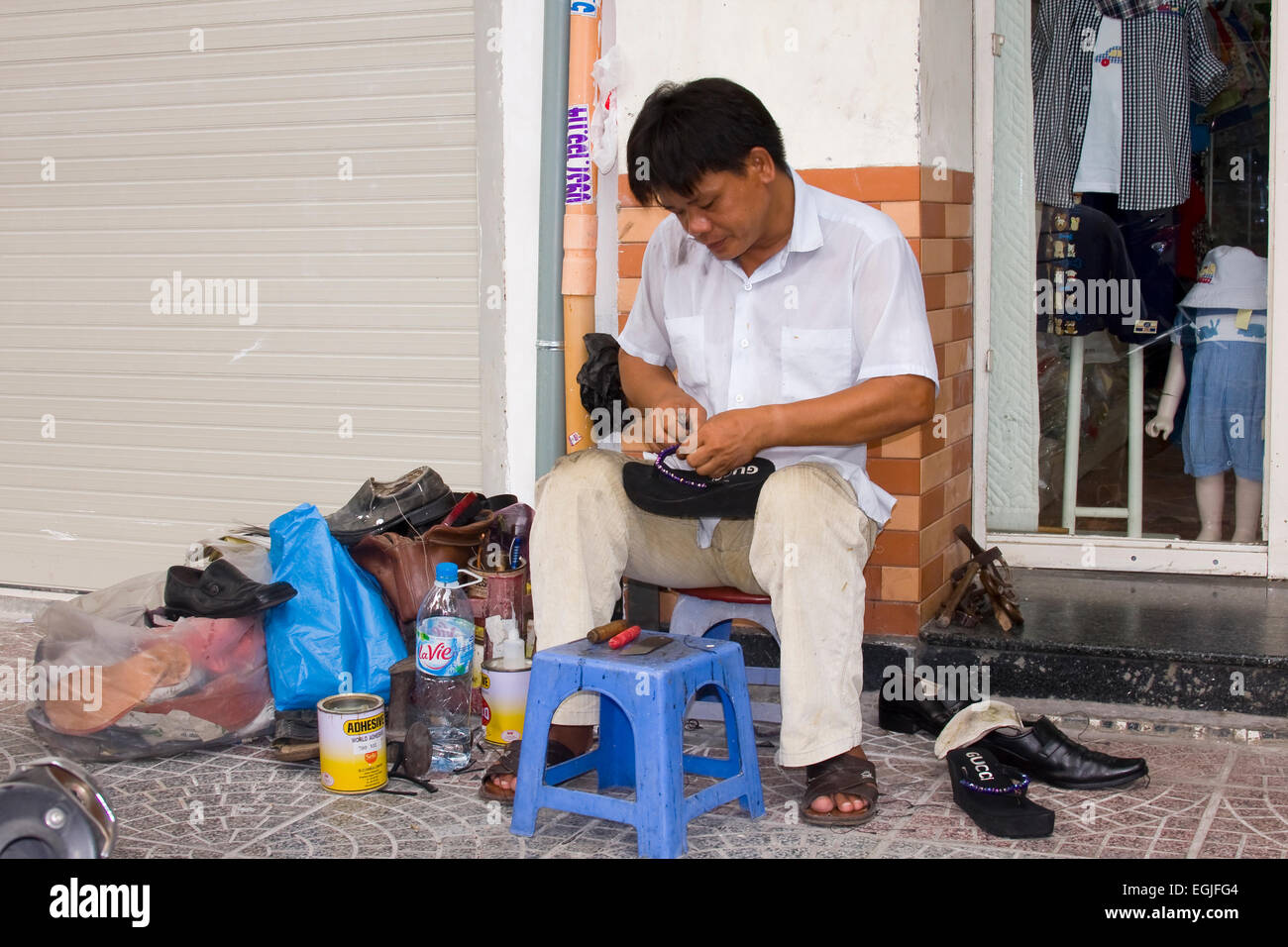 Street shoemaker repairing shoes, Saigon, Ho Chi Minh City, Vietnam, Asia Stock Photo