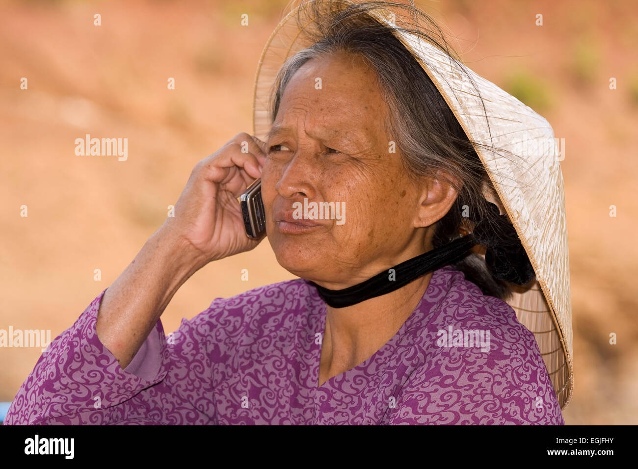 Portrait of an old Vietnamese woman phoning with a mobile phone, Dalat Vietnam, Asia Stock Photo