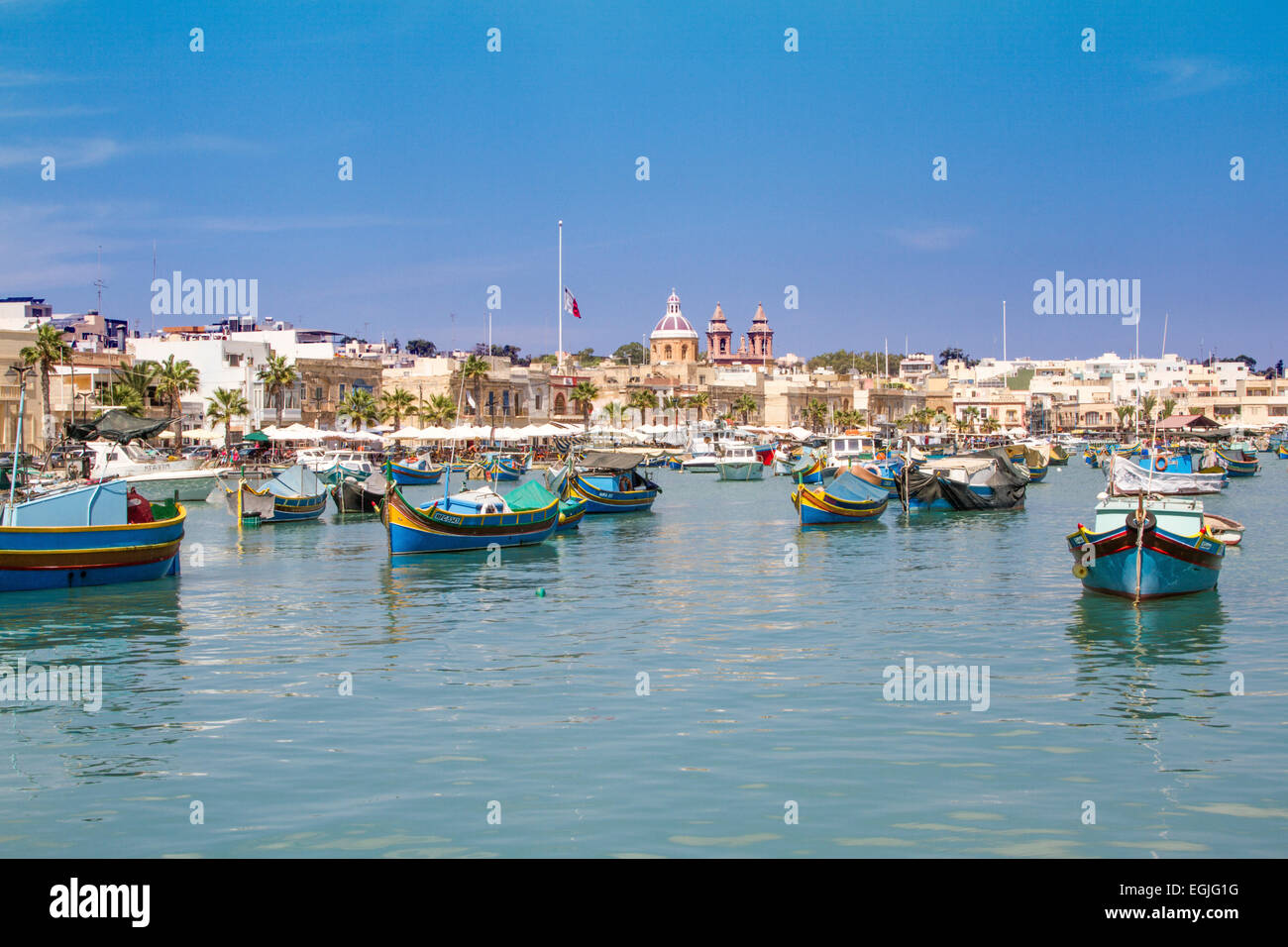 Picturesque landscape of numerous Luzzu traditional fishing boats in Marsaxlokk harbour, Malta Stock Photo