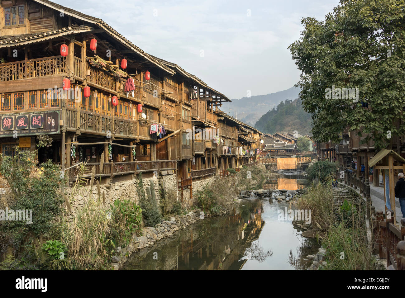 Dong village with stilt houses and reflections on a small river, Zhaoxing Dong village, Guizhou Province, China Stock Photo