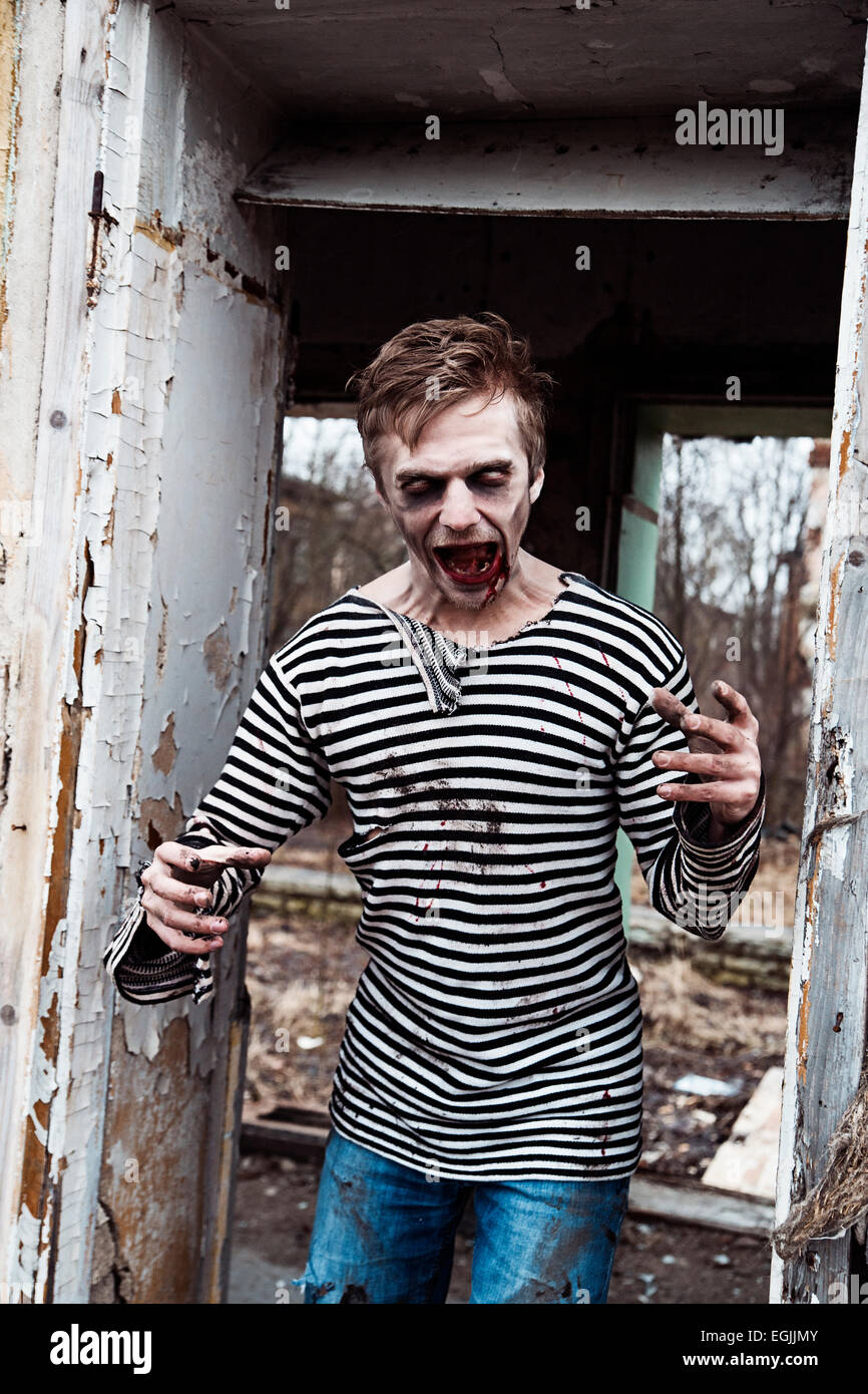 Screaming insane zombie in abandoned empty house Stock Photo