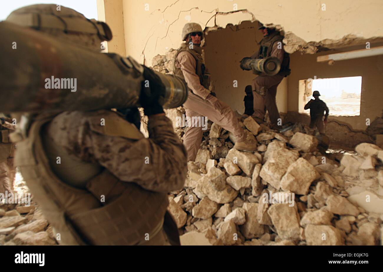 US Marines lugs tube-launched optically-tracked wire-guided missiles for placement in a building set for demolition to eliminate weapons and safe haven for insurgents July 30, 2008 in Al-Taqaddum, Iraq. Stock Photo