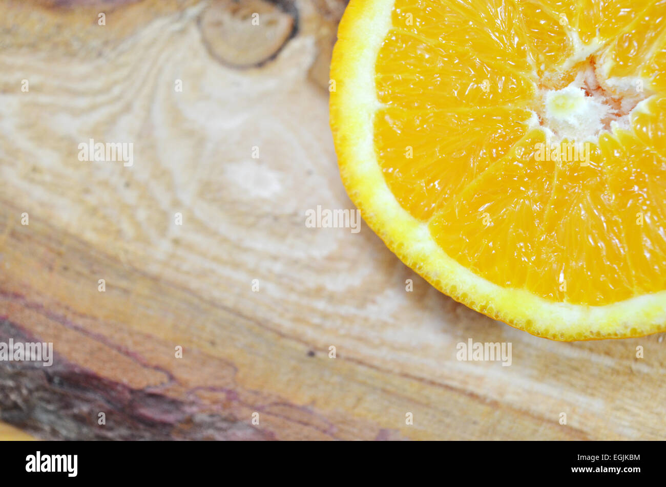 One half of an orange close up on a plank Stock Photo