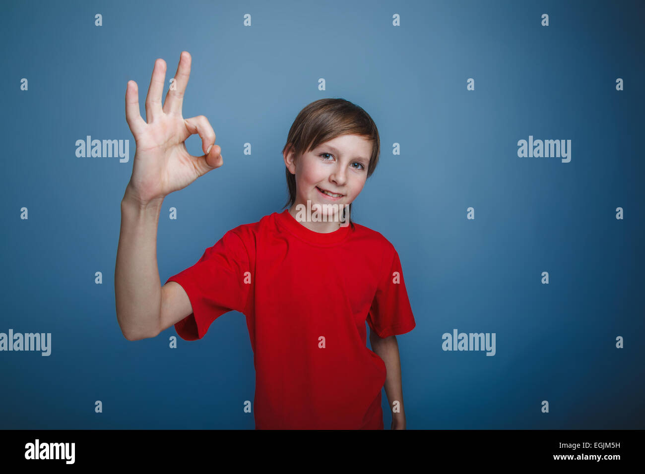 teenager boy twelve years old European appearance showing OK sign on a