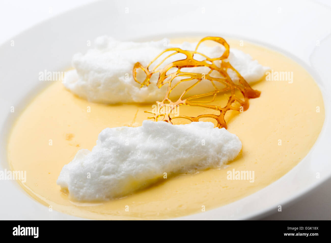 Floating islands, fluffy poached meringue on a lake of custard made from egg yolks, milk, sugar and vanilla, topped with a caram Stock Photo