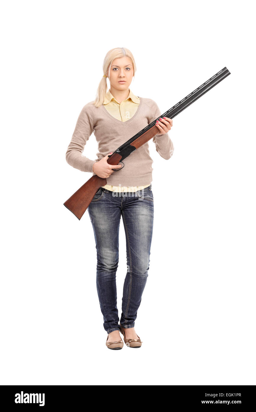 Full length portrait of a serious girl holding a shotgun isolated