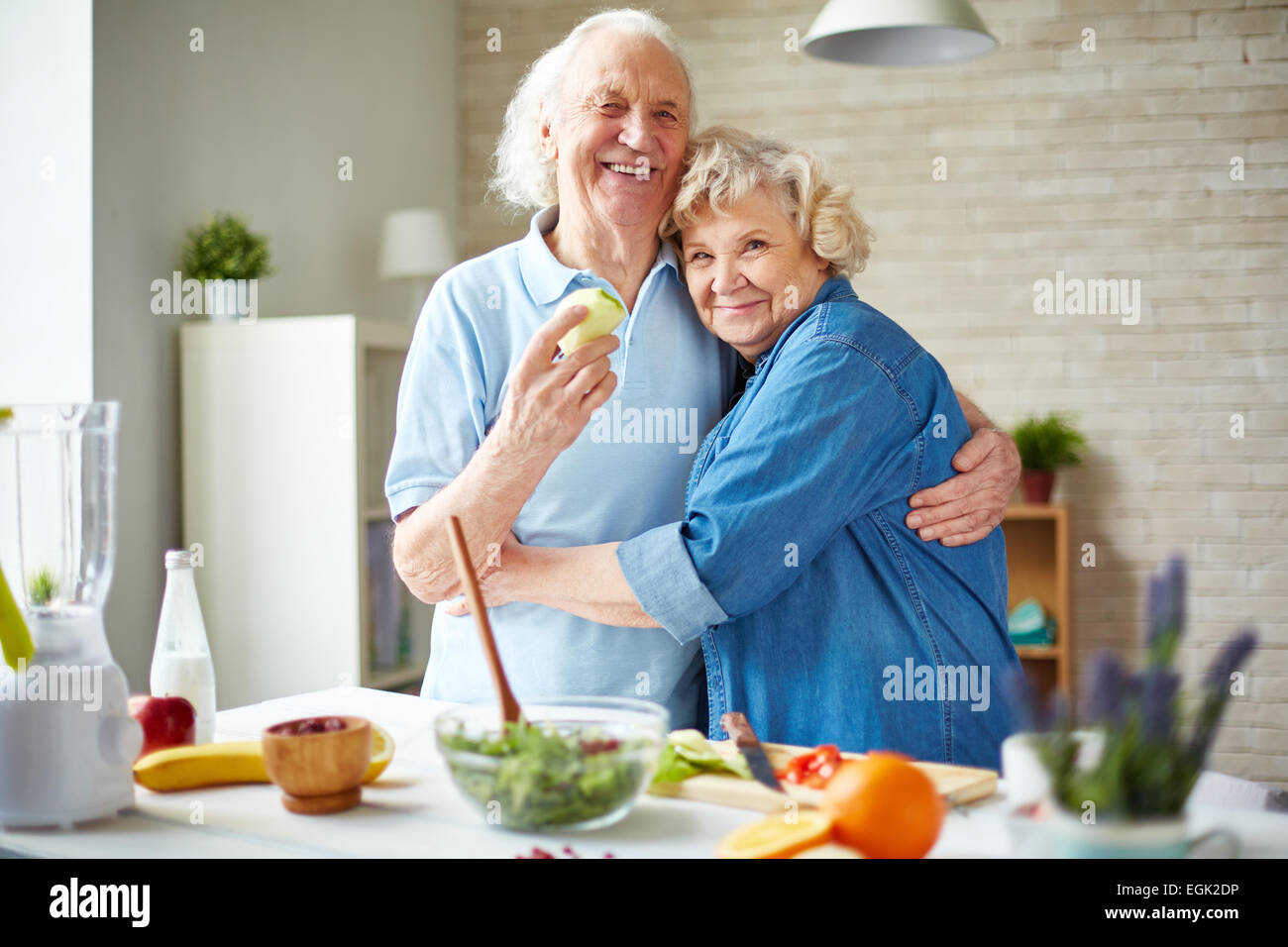 Affectionate seniors in embrace looking at camera Stock Photo