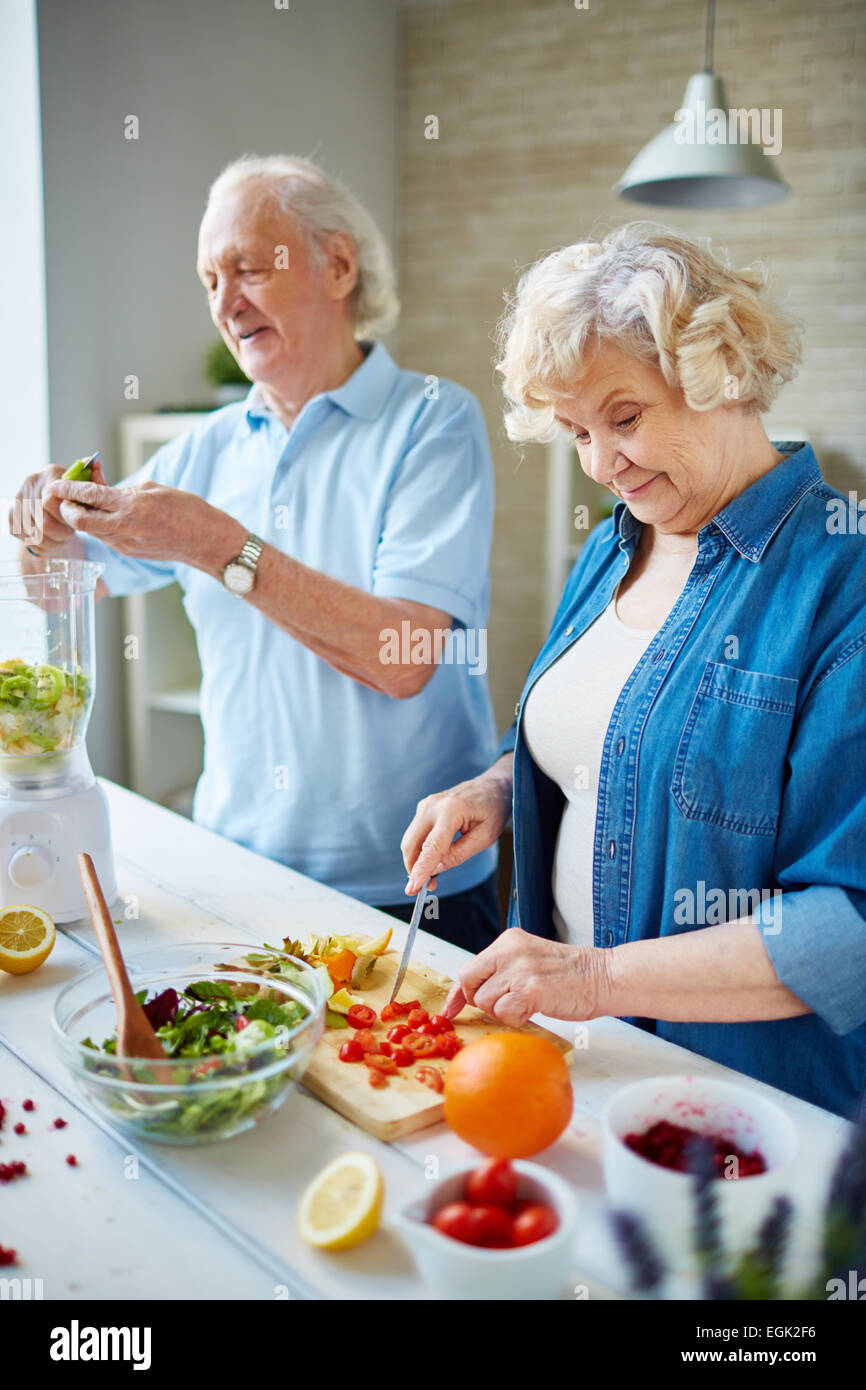 Senior husband and wife cooking together Stock Photo