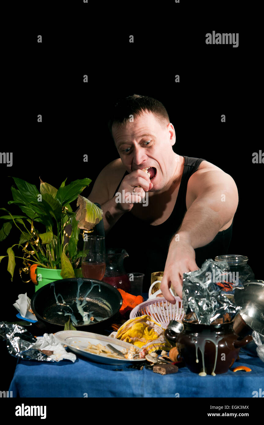 adult  man in black shirt sits behind dirty table Stock Photo