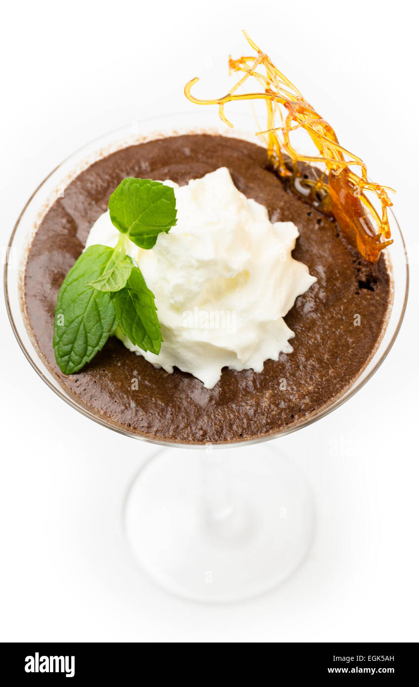 Homemade chocolate mousse in a martini glass with cream, a sprig of mint and a caramelised sugar decoration Stock Photo