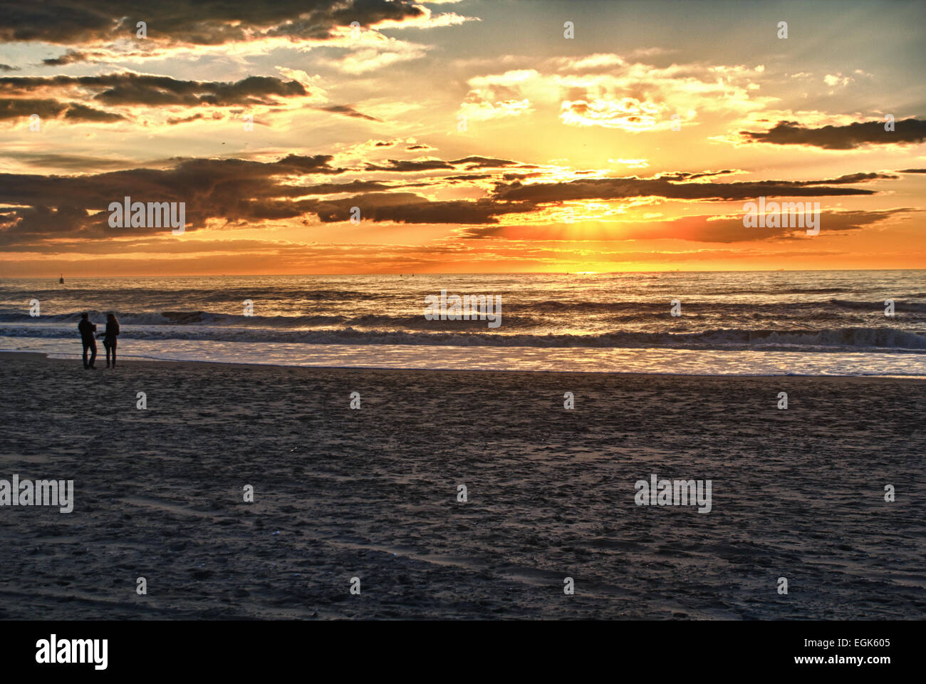 Happy family walking on the beach at sunrise or sunset for holiday time Stock Photo