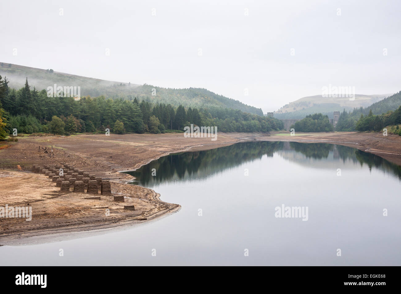 Looking across Derwent reservoir to Howden Dam with low water levels revealing the structure of an old railway. Stock Photo