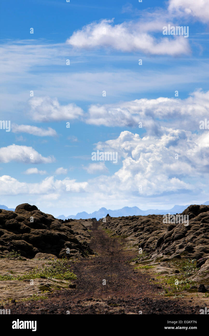 A dirt road through a lava field in Iceland, towards Myrdalsjokull glacier and Katla volcano. Stock Photo