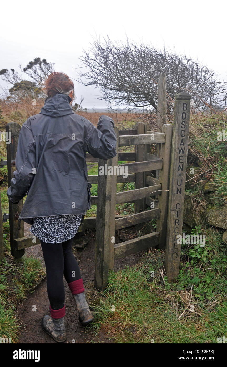 A female walker passes though a stile in the Cornish countryside Stock Photo