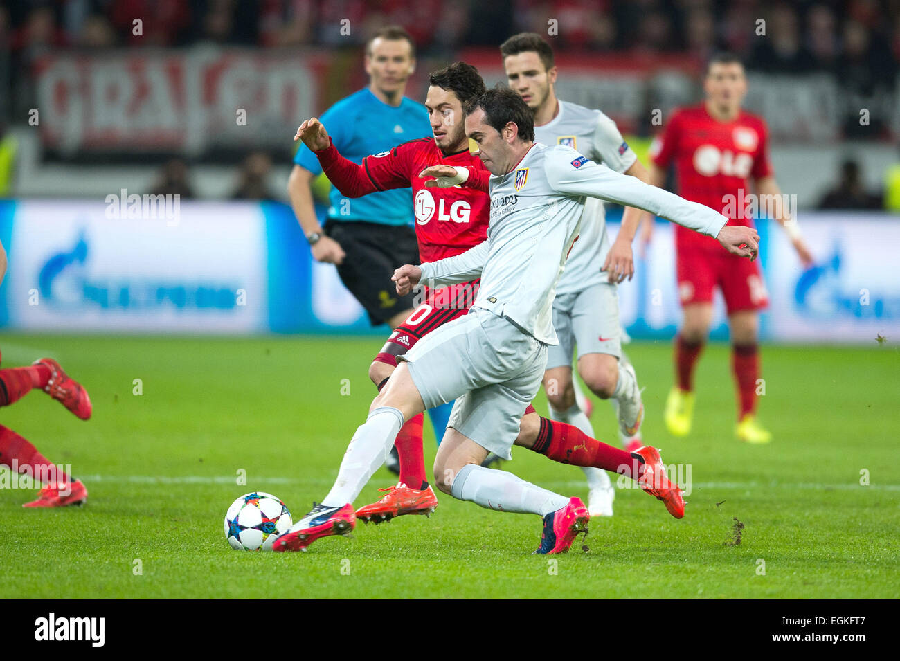 Leverkusen, Germany. 25th Feb, 2015. Leverkusen's Hakan Calhanoglu and Diego Godin compete for the ball during the Champions League round of 16 first leg match between Bayer Leverkusen and Atletico Madrid in Leverkusen, Germany, 25 February 2015. Photo: Maja Hitij/dpa/Alamy Live News Stock Photo