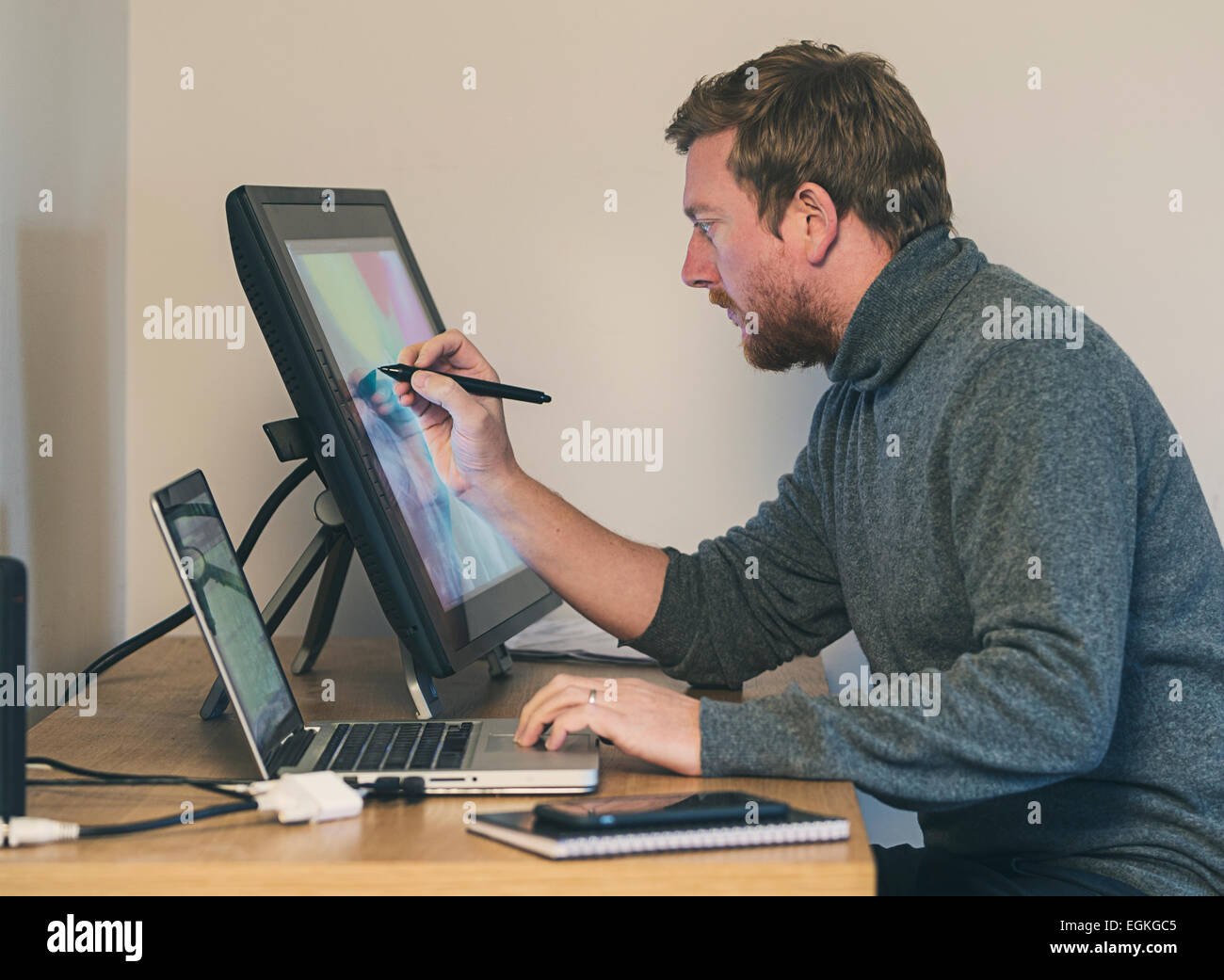 Creative Man at Desk with Touch Screen Tablet Stock Photo