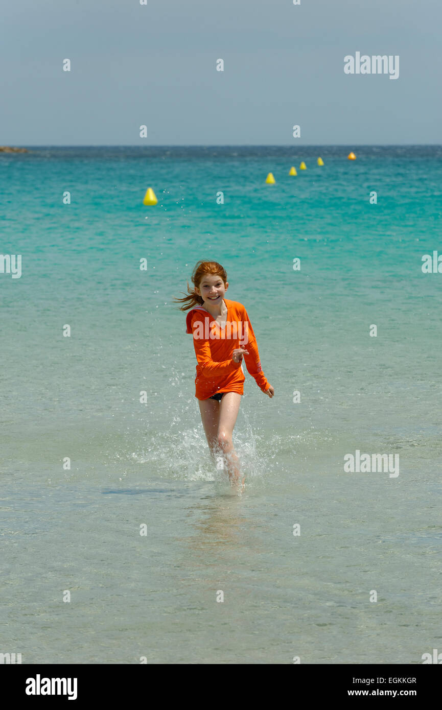 Girl running through the turquoise waters of the Bay of Rondinara, southeast coast, Corsica, France Stock Photo