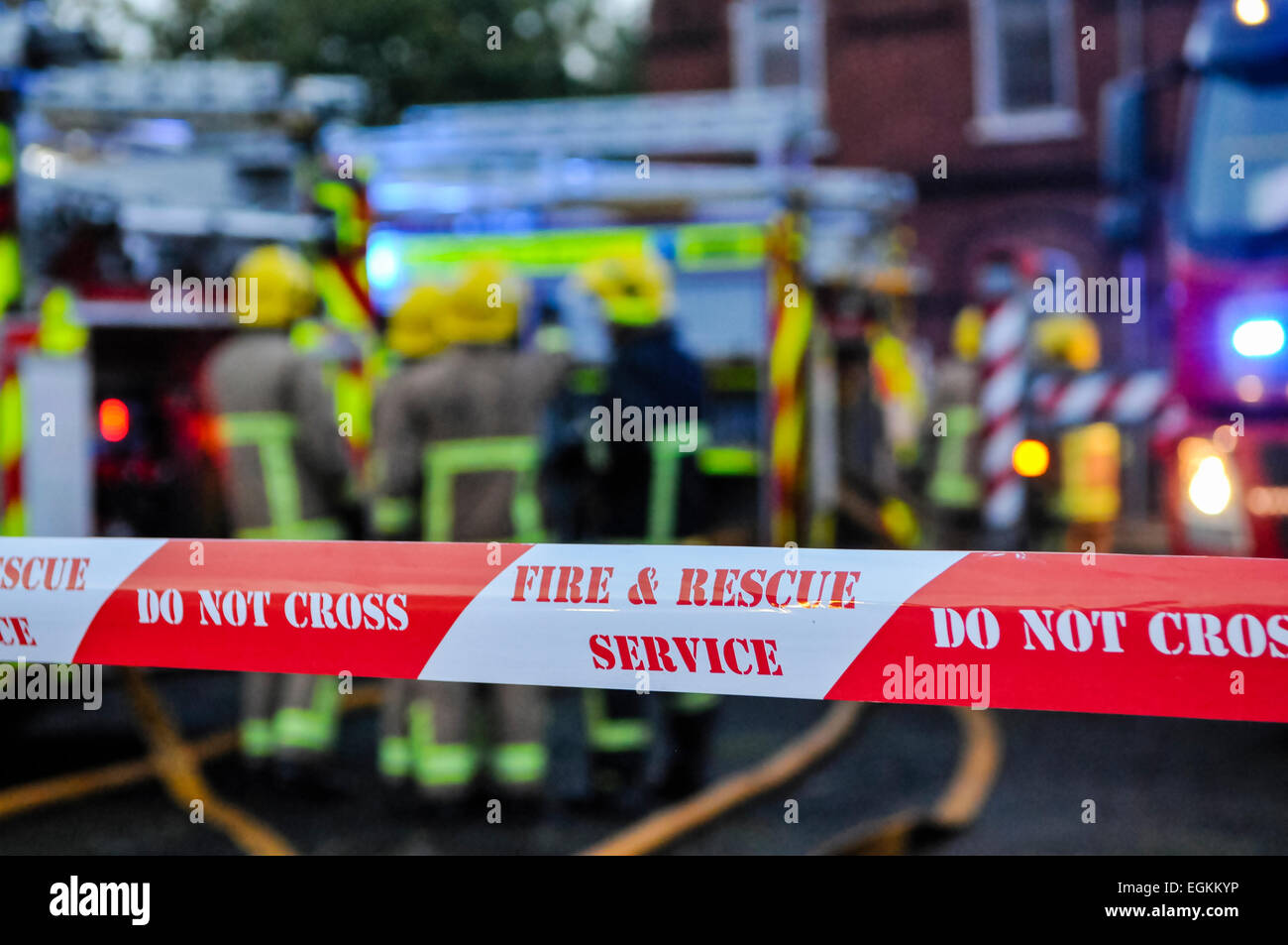 Fire brigade place cordon tape around a suspected arson scene to keep people safe and preserve evidence. Stock Photo