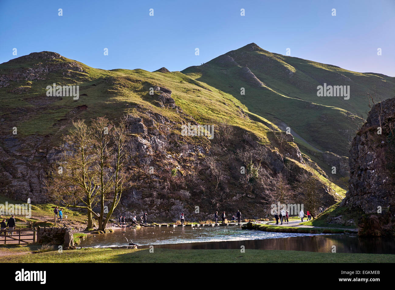 People on the famous Stepping Stones across the River Dove in Dovedale with Thorpe Cloud beyond. Ilam, Derbyshire, England. [Pea Stock Photo