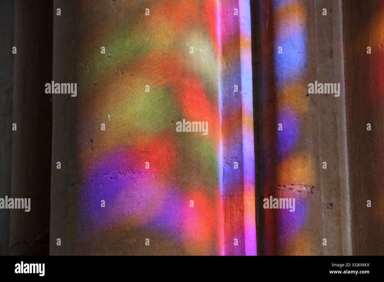 Psychedelic coloured colored light from stained glass window projected on pillar inside the Sagrada Familia Stock Photo