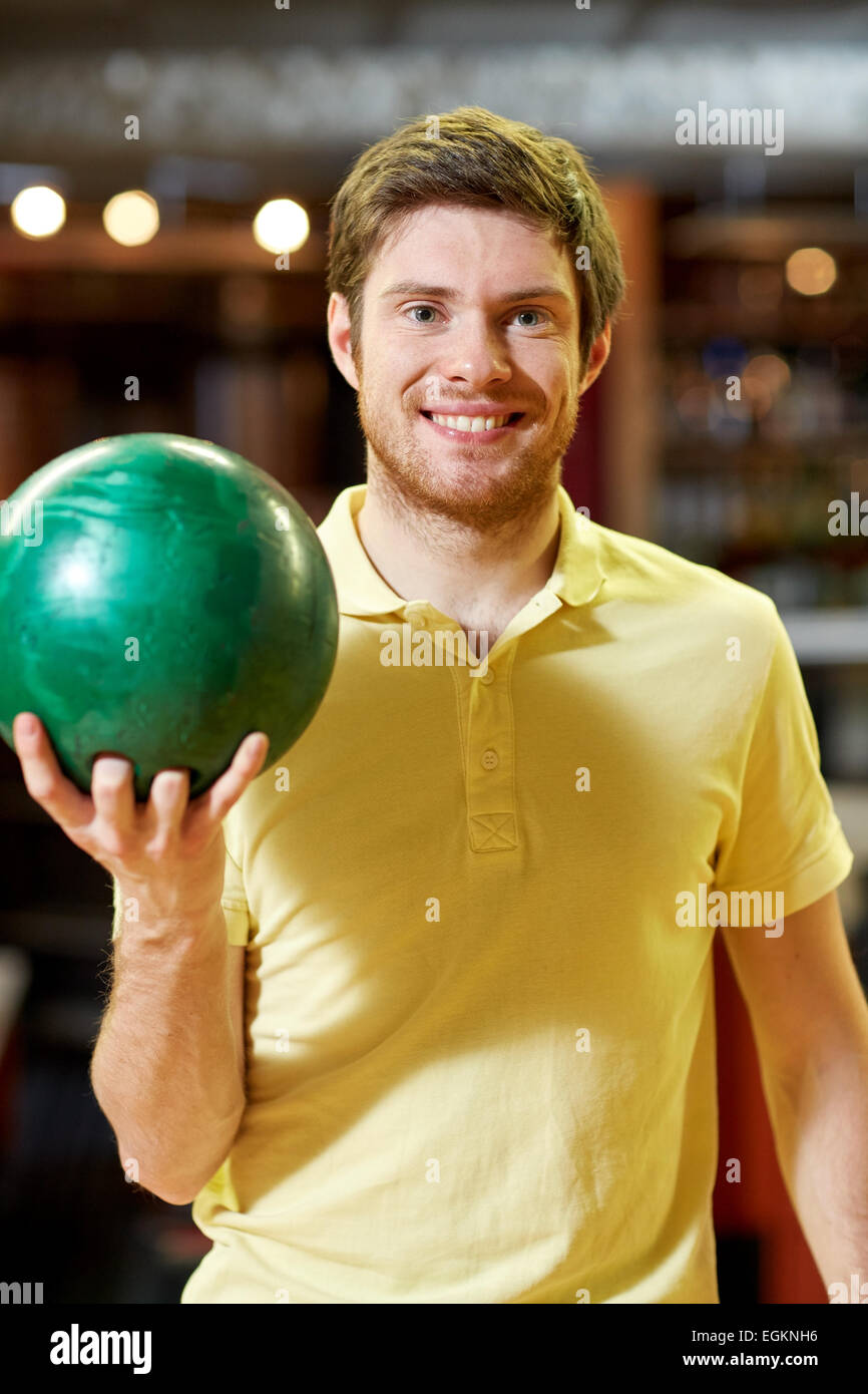 happy young man holding ball in bowling club Stock Photo