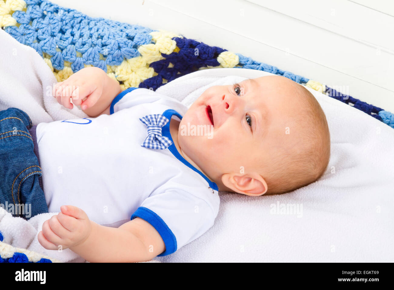 Cute baby boy laughing on white blanket Stock Photo