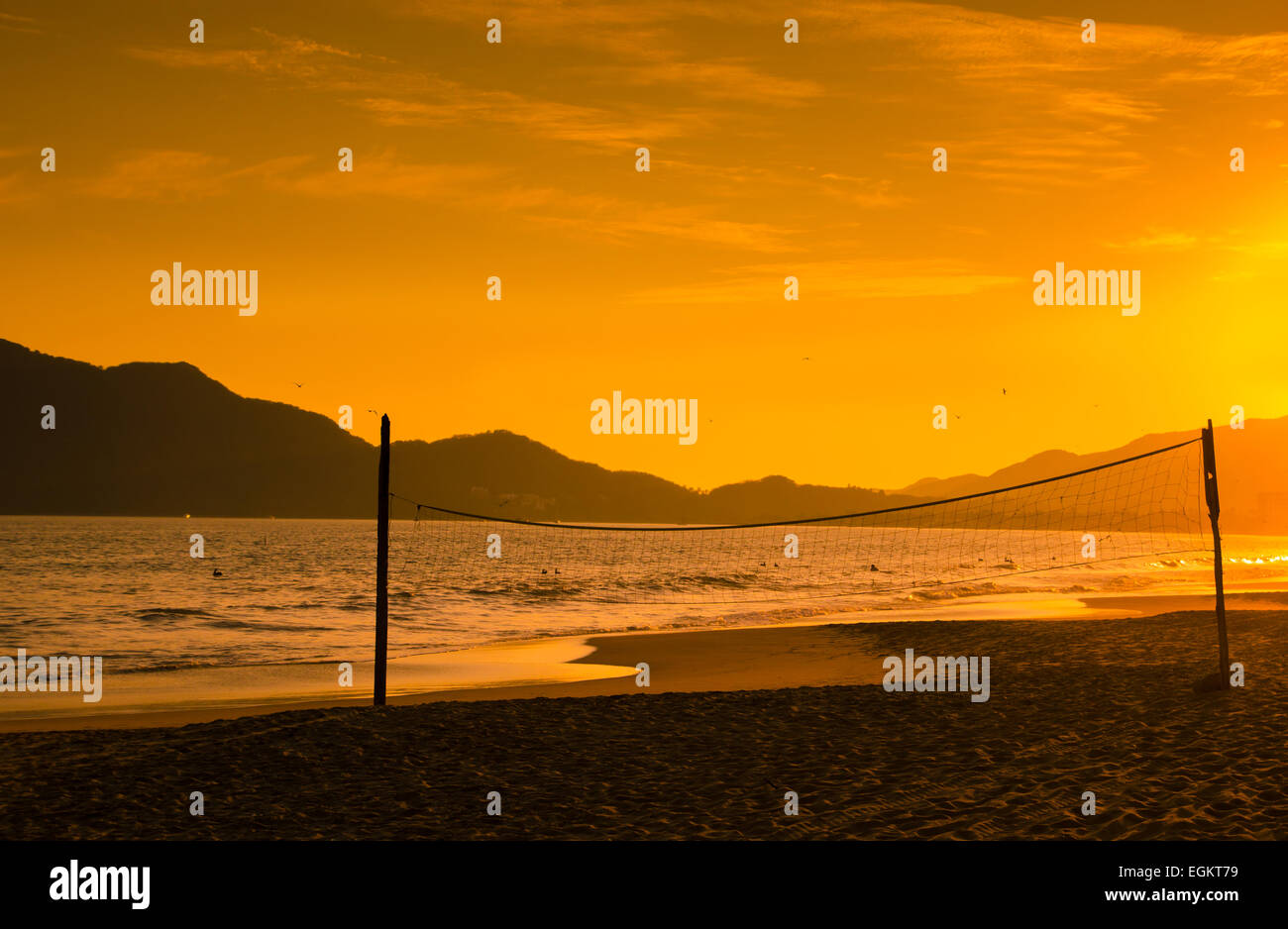 A dramatic sunset silhouettes a beach volleyball net at Miramar Beach near Manzanillo, Colima, Mexico Stock Photo
