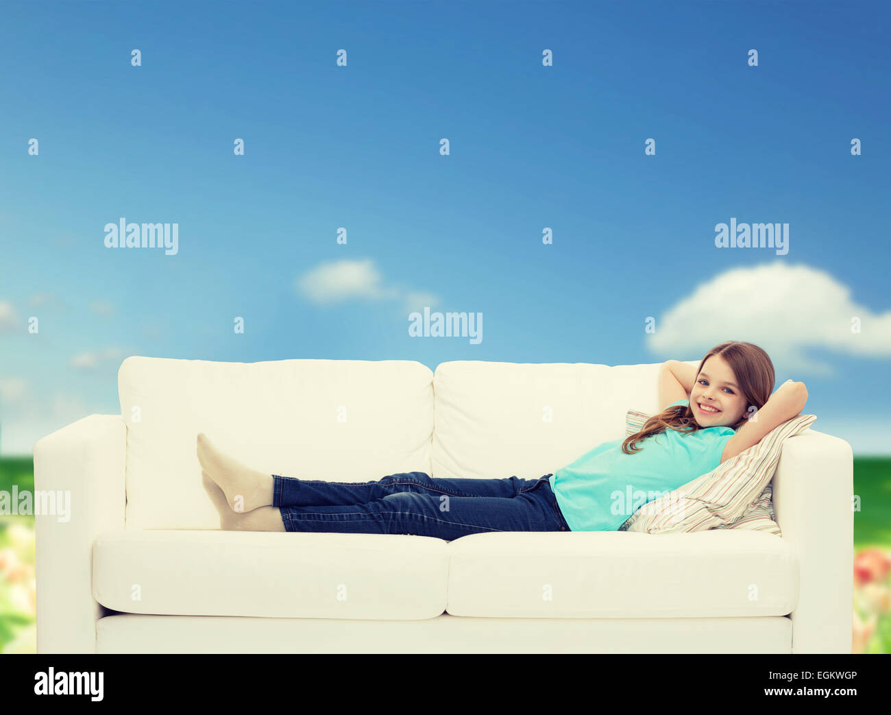 smiling little girl lying on sofa Stock Photo - Alamy
