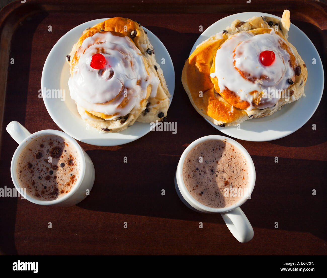 Two belgium buns and mugs of hot chocolate on a tray Stock Photo