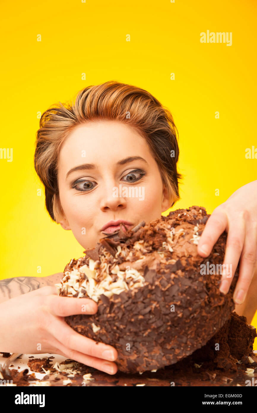 Young woman holding a large chocolate cake. Stock Photo