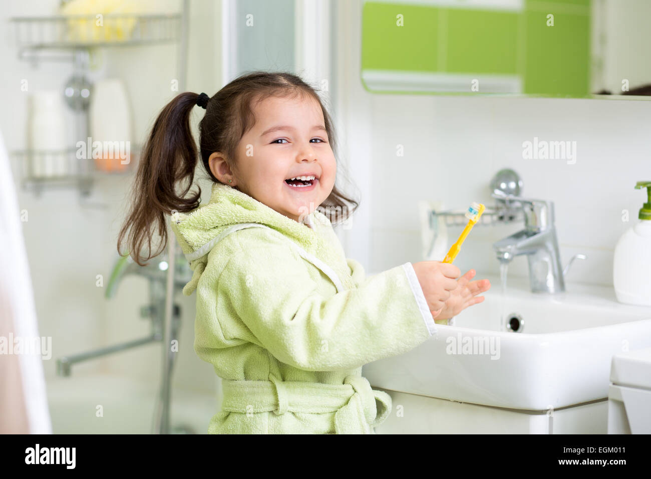 Smiling little girl brushing teeth in bath Stock Photo Alamy