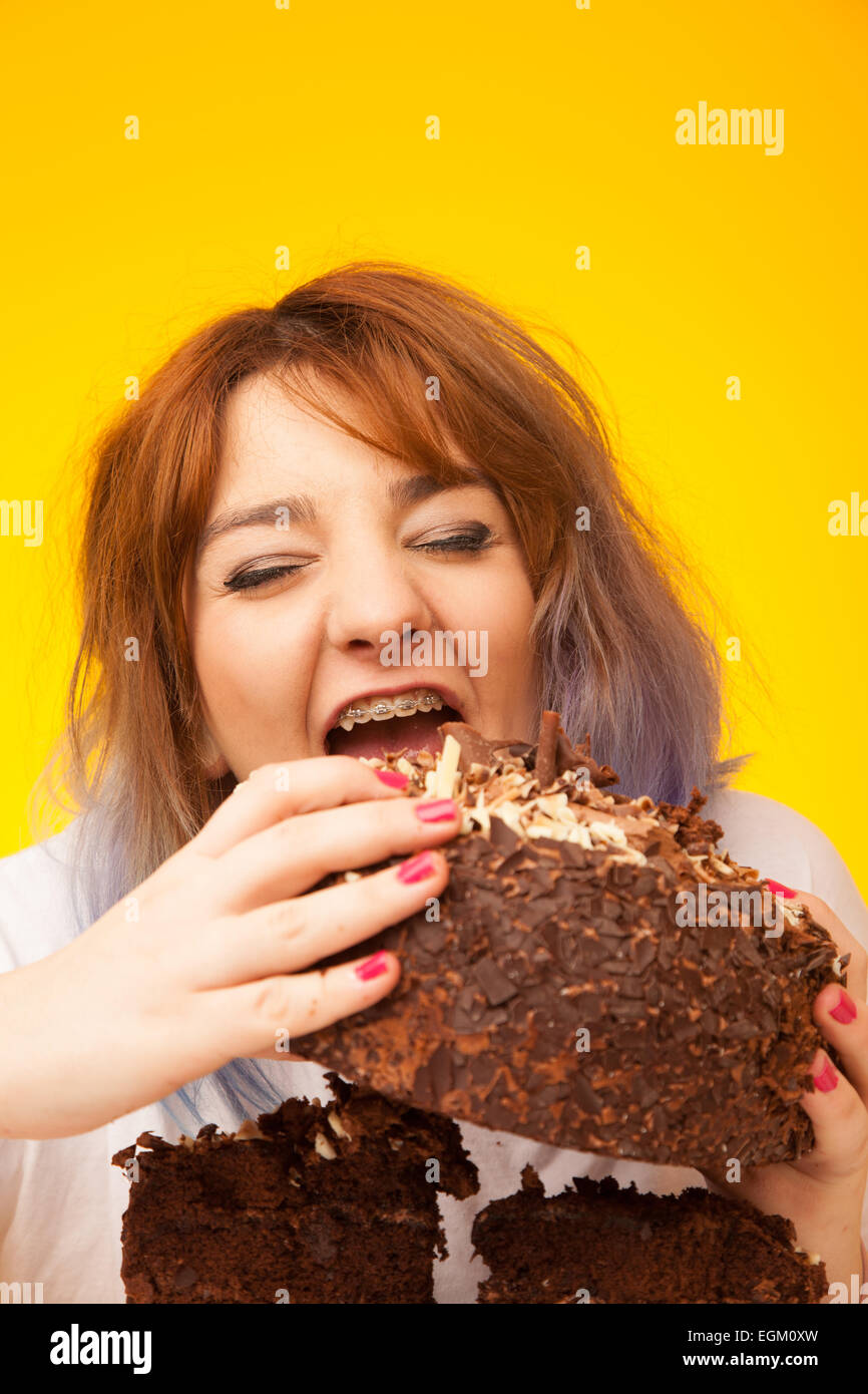 Young woman about to eat a large chocolate cake. Stock Photo