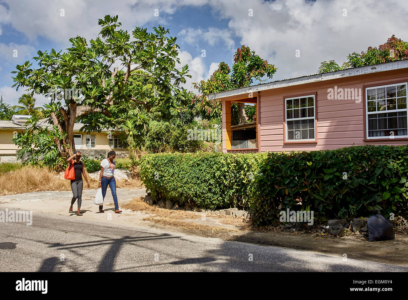 Barbados wooden house chattel painted pink, two young women walking