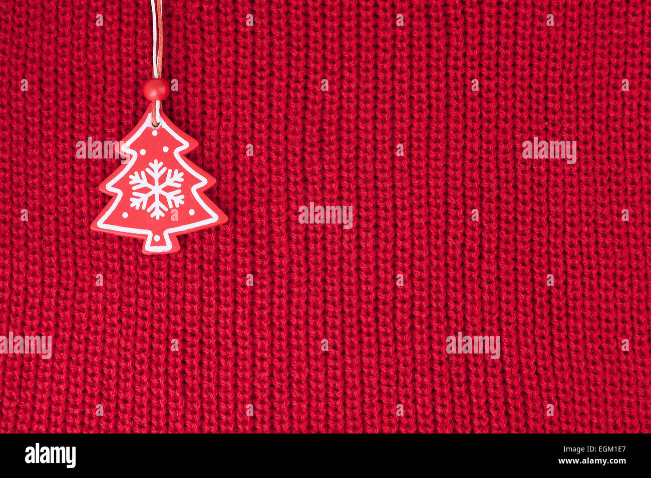 Christmas fir tree decoration on red wool knitted fabric background Stock Photo