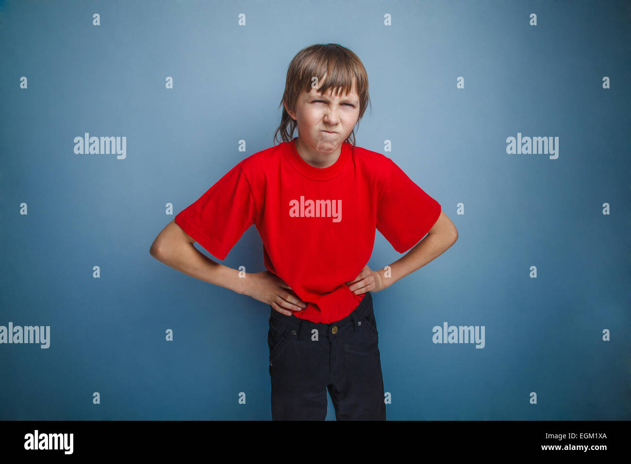 Boy, teenager, twelve years in the red shirt, hands in the side, Stock Photo