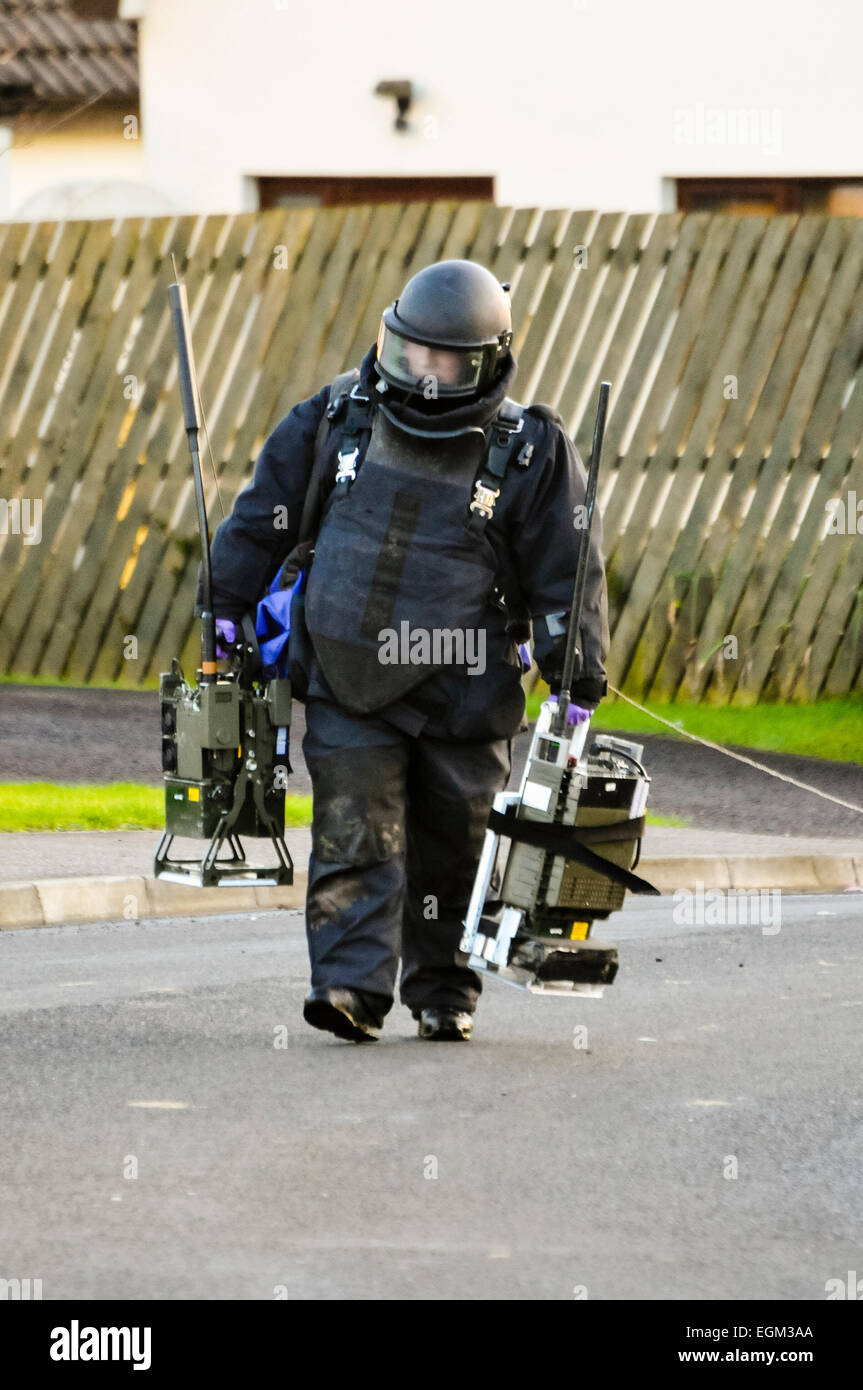 Carrickfergus, Northern Ireland. 20 Jan 2014 - Army ATO dressed in a protective suit carries two Electronic Counter Measure units (ECM) used to jam radio frequencies and prevent remote detonation of devices. Stock Photo