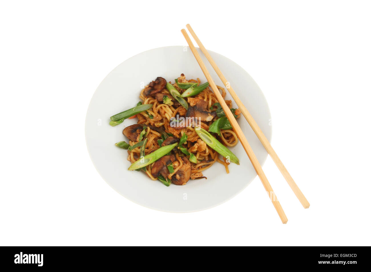 Chinese egg noodle stir fry in a bowl with chopsticks isolated against white Stock Photo