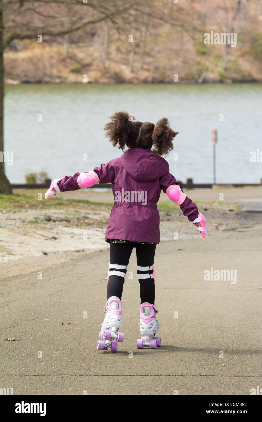 Toddler learning to roller skate in park without helmet Stock Photo Alamy