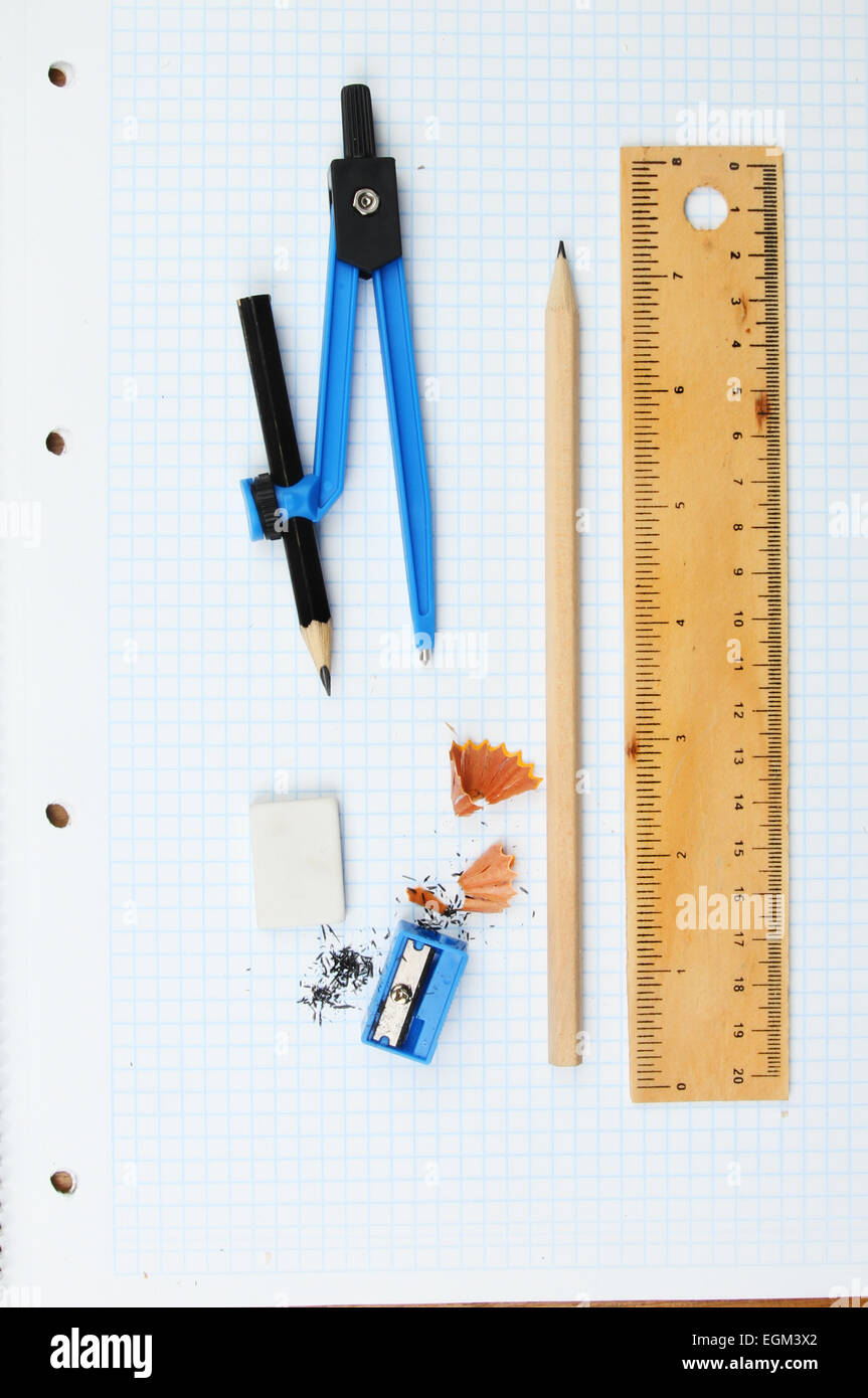 Rule, compass, pencil, sharpener, eraser and shavings on graph paper Stock Photo