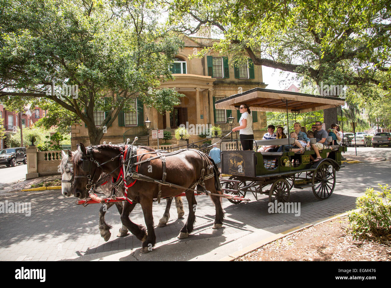 A horse carriage passes the Owens Thomas historic house in Savannah