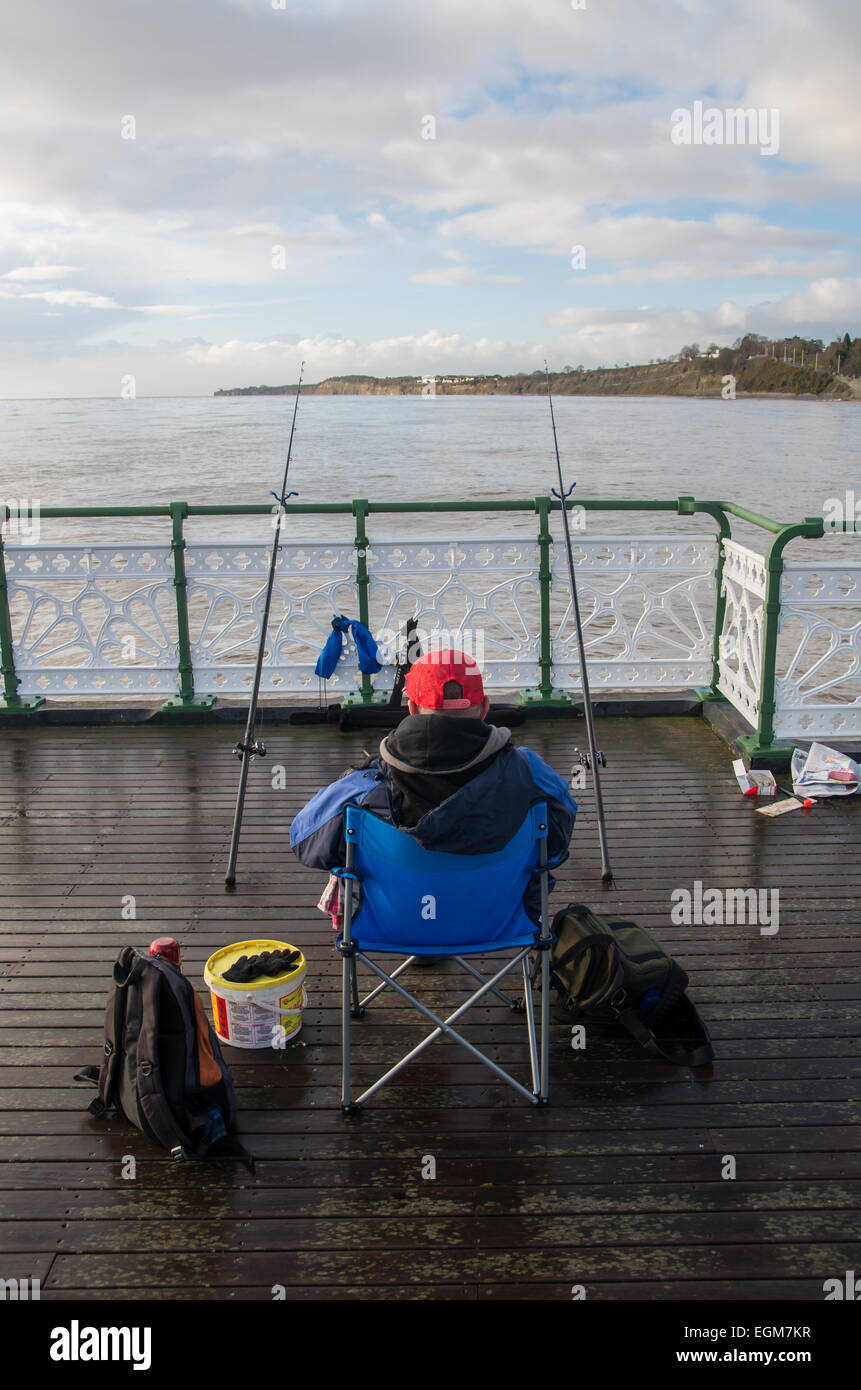 An image of a sea fisherman angling off the award winning Penarth pier Stock Photo