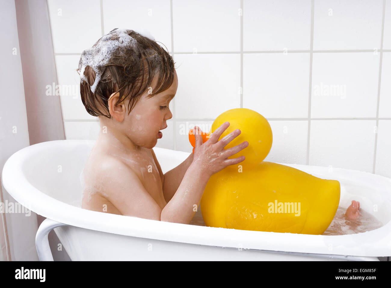 adorable little boy washing his rubber duck Stock Photo