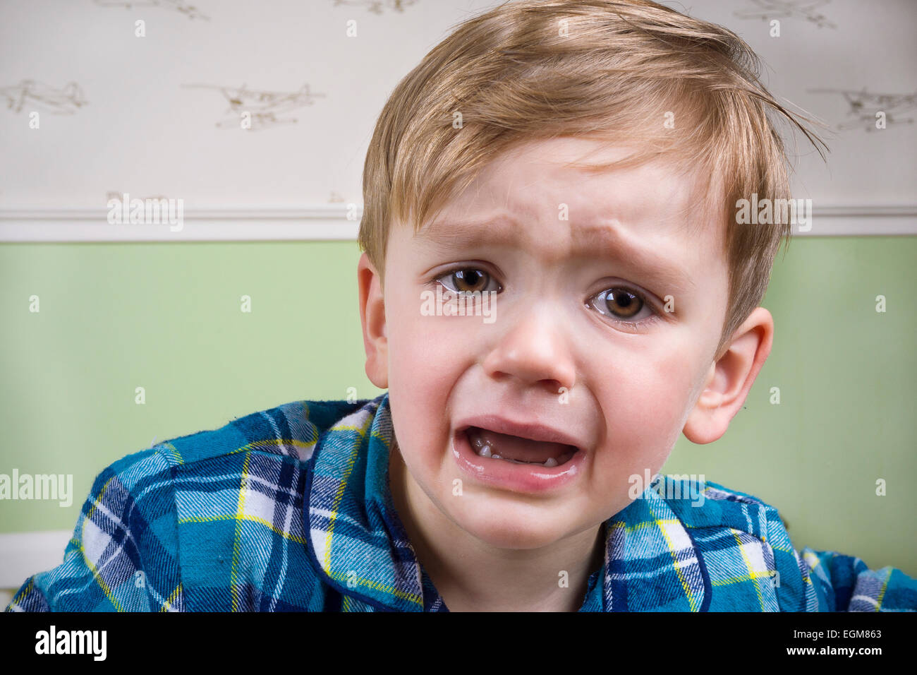 Small boy crying dramatically before bedtime Stock Photo