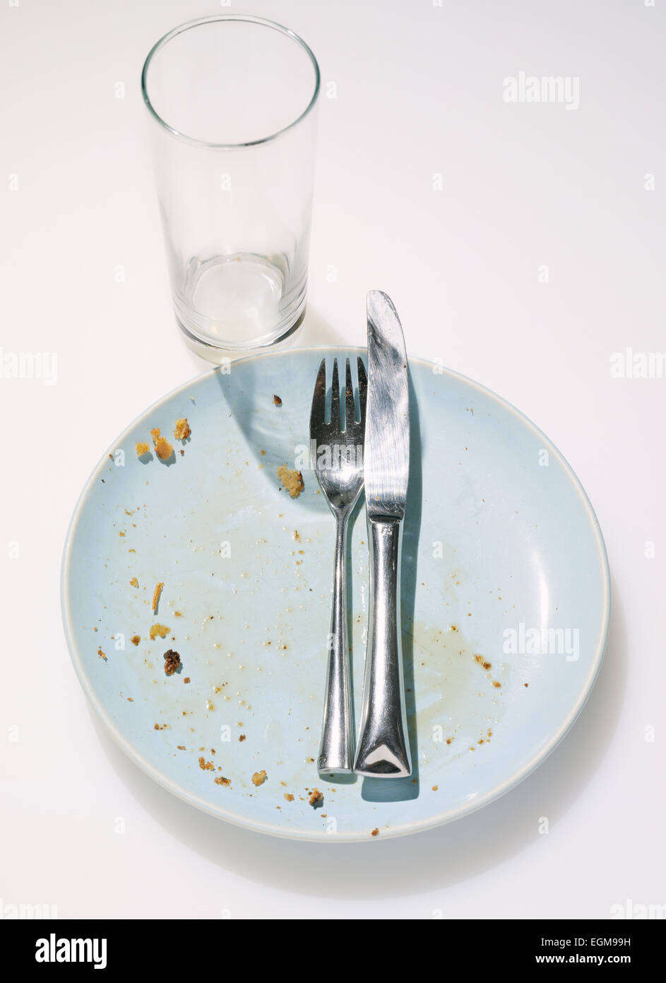 Crumbs and Silverware on Dirty Plate Stock Photo