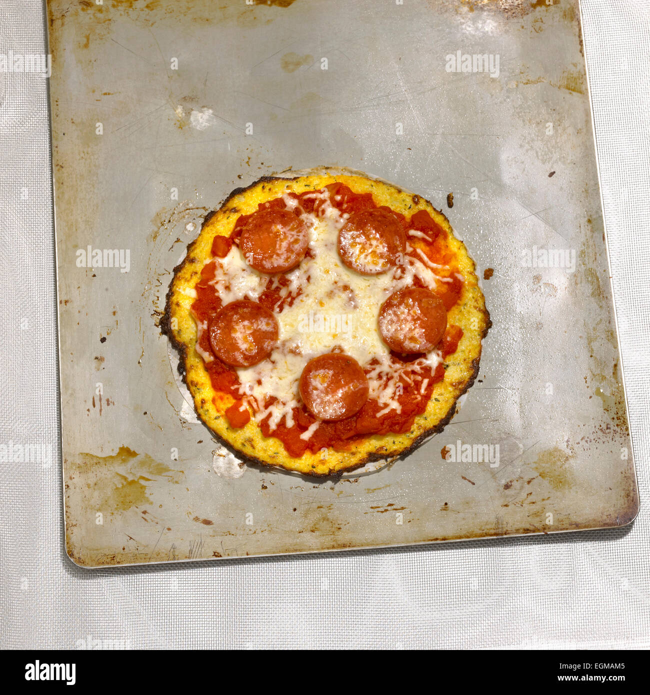 Small Cauliflower Crust Pepperoni Pizza on Baking Sheet Stock Photo