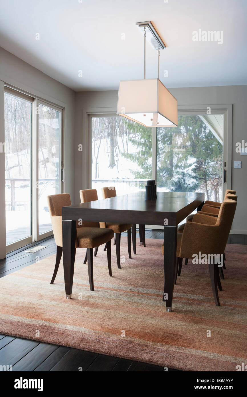 Dining Room Table With Upholstered Orange Chairs On Area Rug And