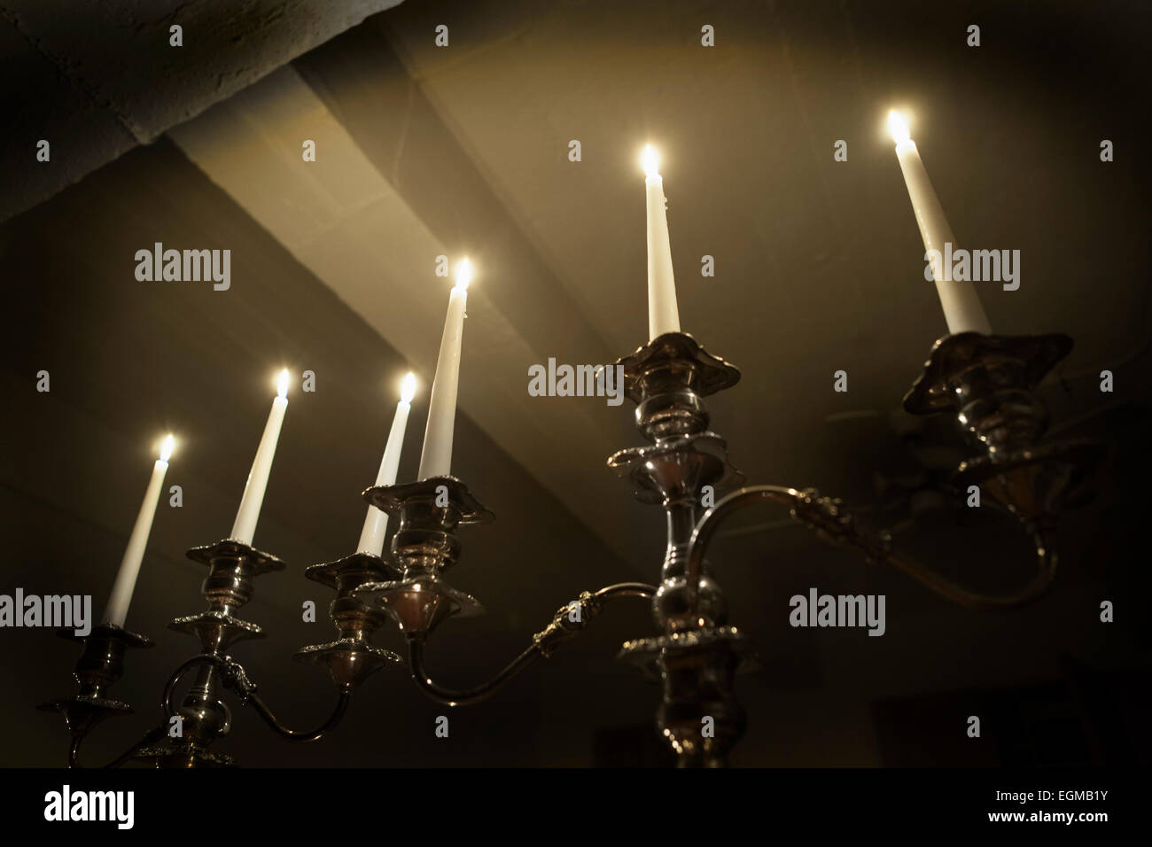 Old Silver Candelabras with Lit Candles in Dark Room, Low Angle View