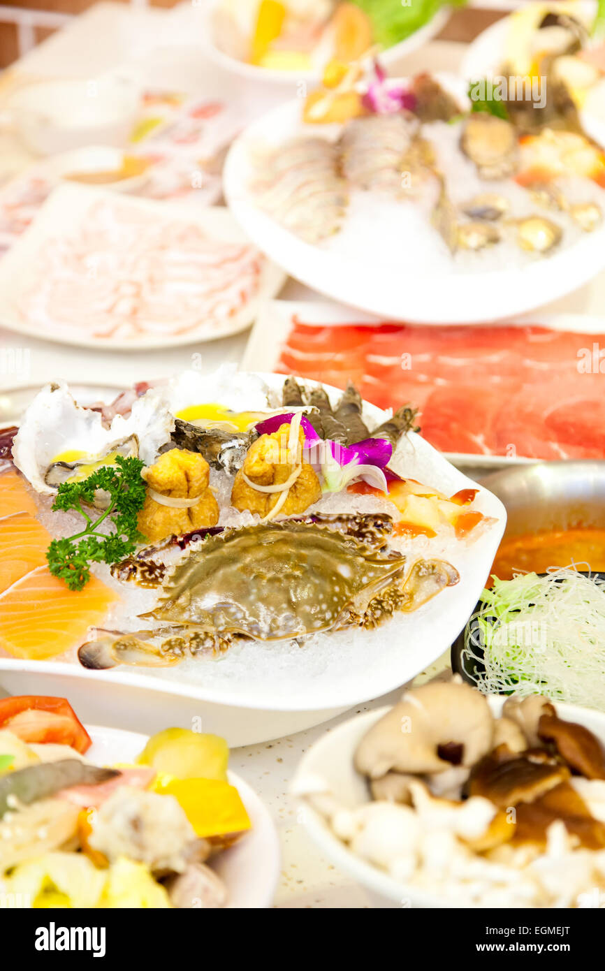 The Chinese hot pot food set - seafood and meat on table in a restaurant Stock Photo